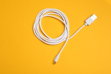 Photo of One USB charge cable on orange background, top view