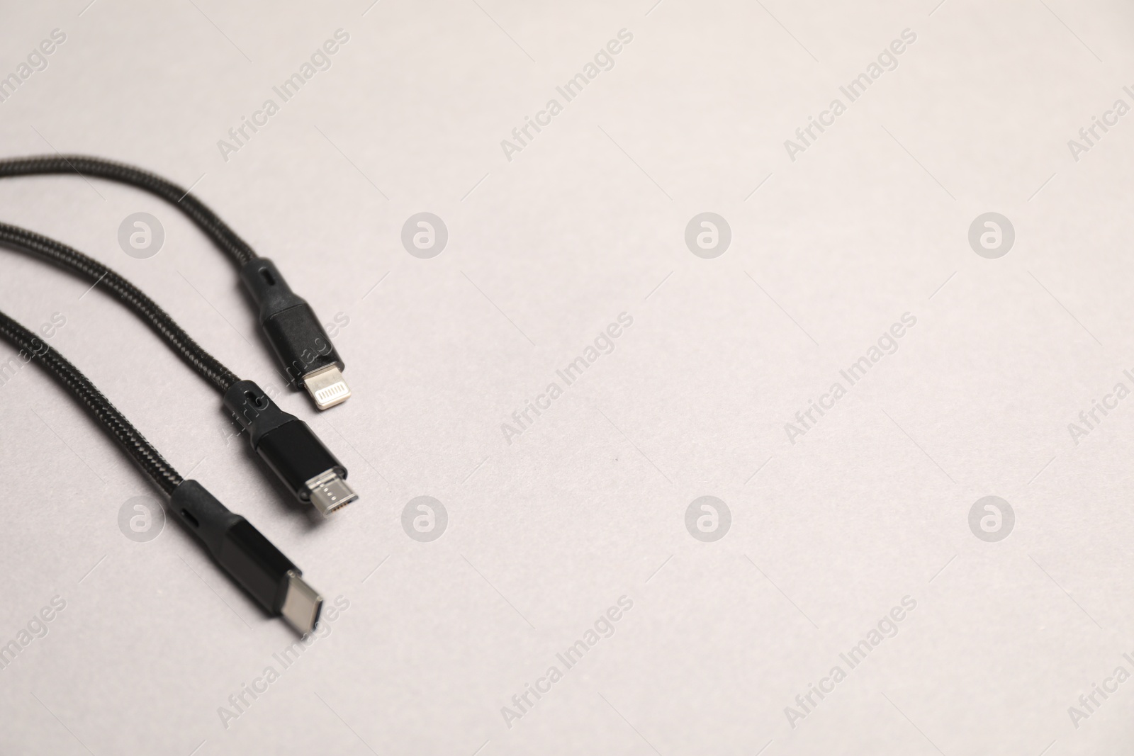 Photo of USB charge cables on light grey background, closeup. Space for text