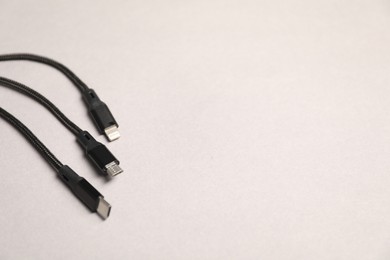 Photo of USB charge cables on light grey background, closeup. Space for text