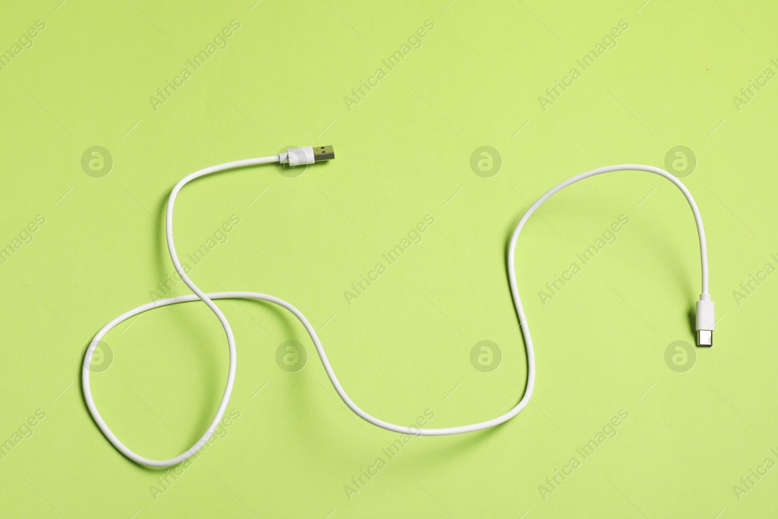 Photo of One USB charge cable on green background, top view