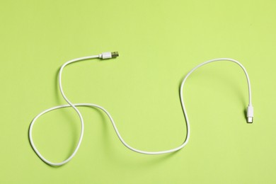 Photo of One USB charge cable on green background, top view