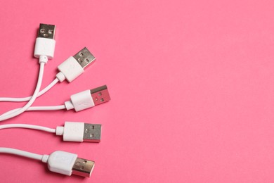 Photo of USB charge cables on pink background, flat lay. Space for text