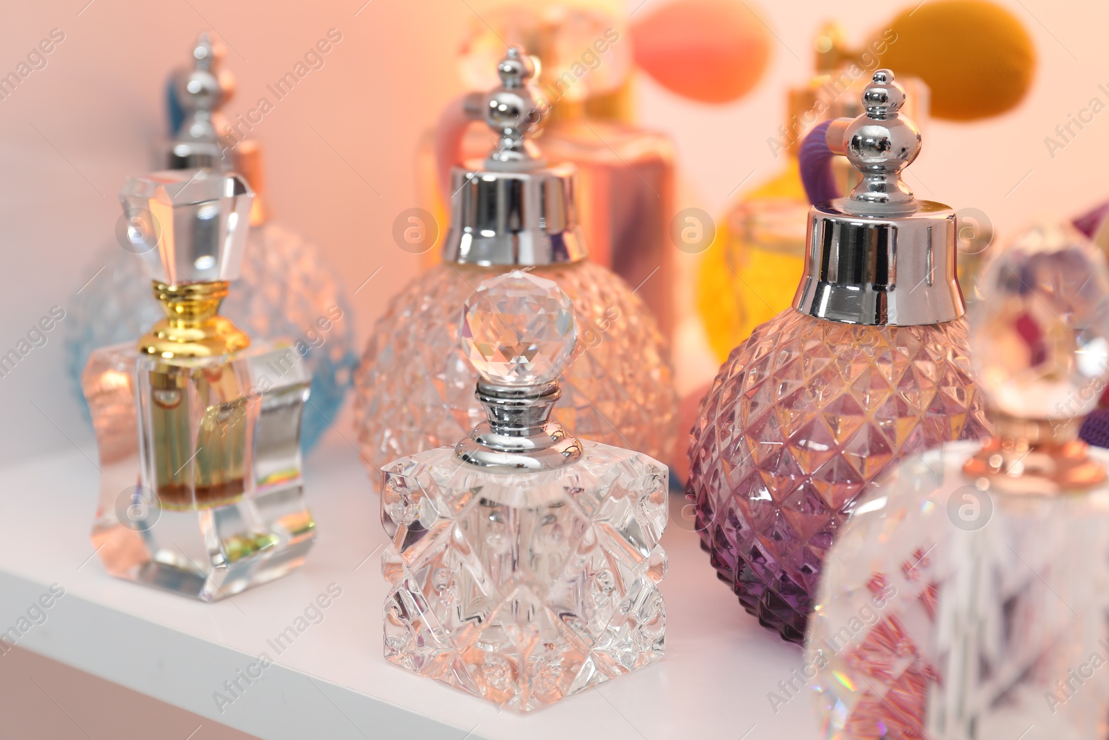 Photo of Different bottles of luxury perfume on shelf in store, closeup