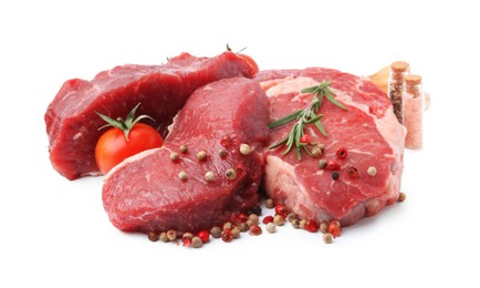 Photo of Pieces of raw beef meat, spices and tomato isolated on white