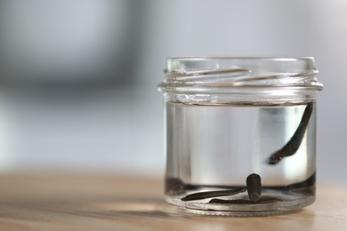 Photo of Medicinal leeches in glass jar on wooden table, closeup. Space for text