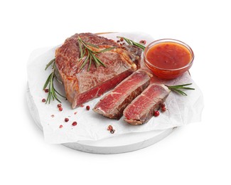 Photo of Pieces of delicious beef meat, spices and sauce isolated on white