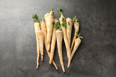 Photo of Parsley roots with leaves on black table, top view