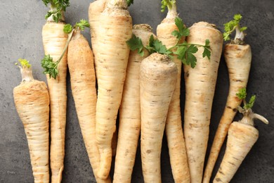 Photo of Parsley roots with leaves on black table, top view