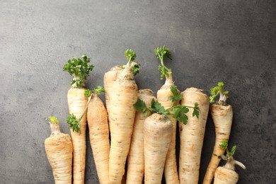 Photo of Parsley roots with leaves on black table, top view