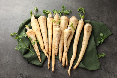 Photo of Parsley roots with leaves on black table, top view