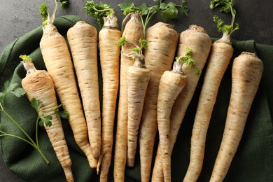 Photo of Parsley roots with leaves on black table, top view