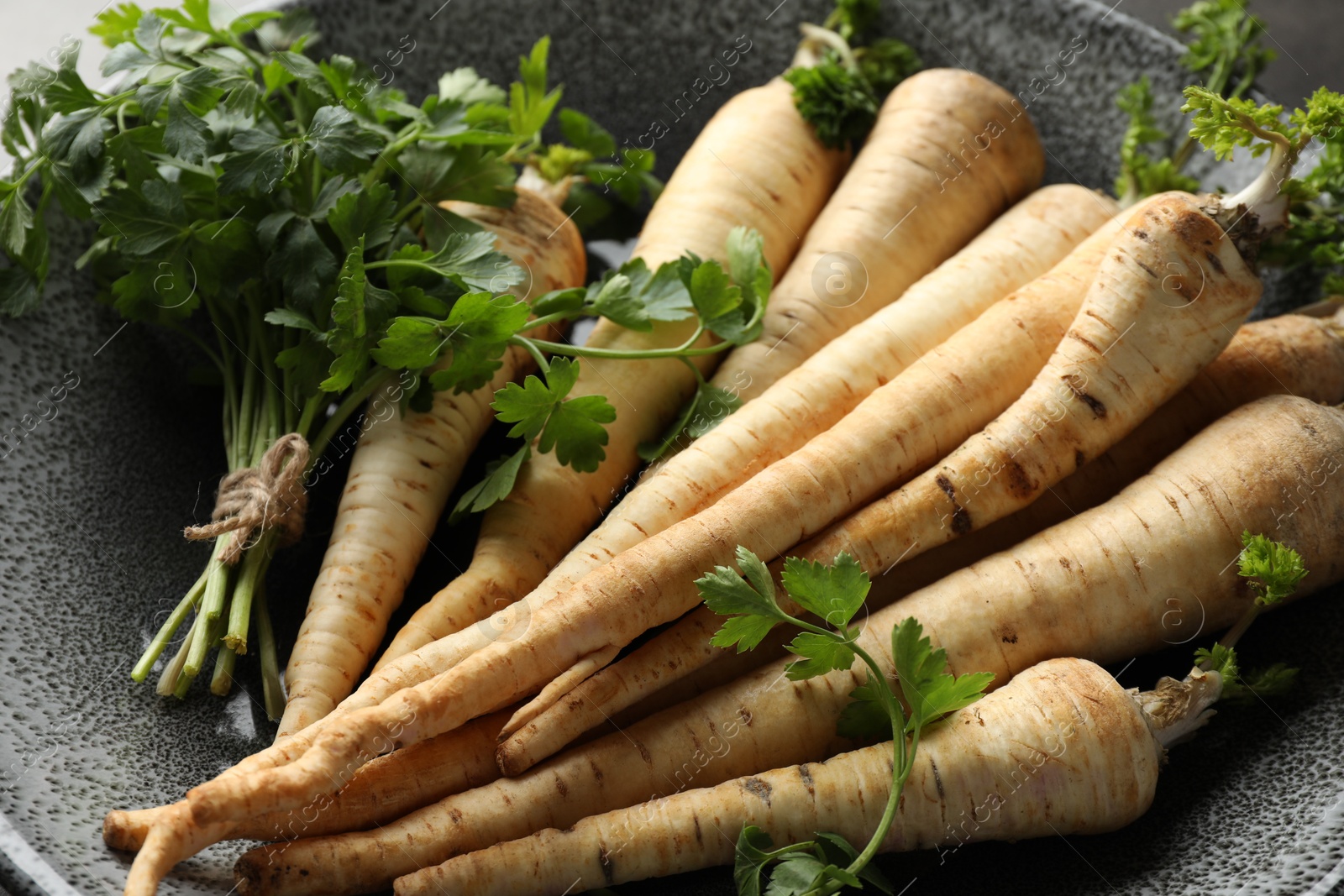 Photo of Parsley roots with leaves on table, closeup