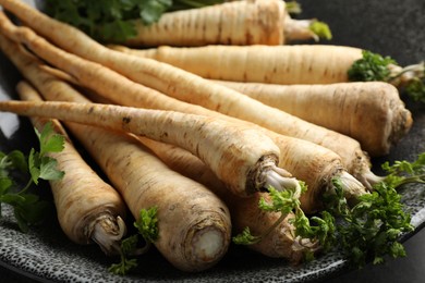 Photo of Parsley roots with leaves on table, closeup