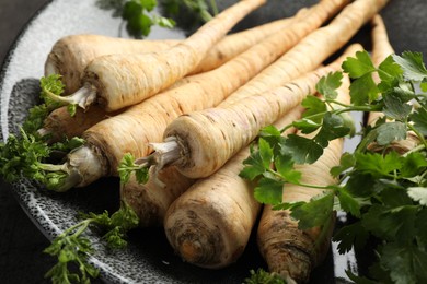 Photo of Parsley roots with leaves on table, closeup