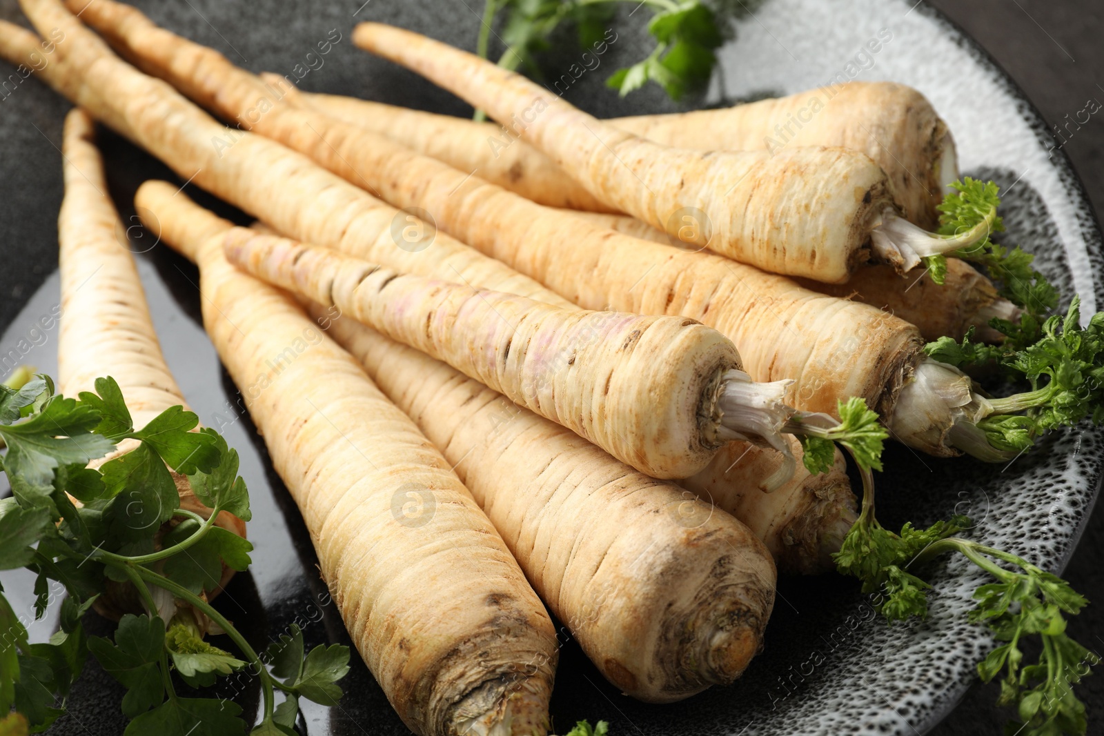 Photo of Parsley roots with leaves on table, closeup