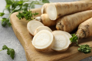 Photo of Parsley roots and leaves on grey table, closeup