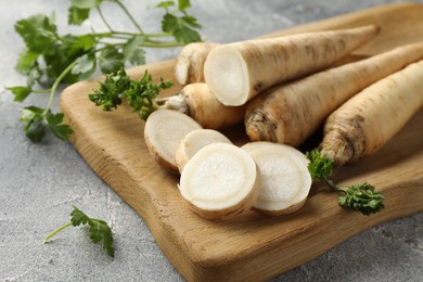 Photo of Parsley roots and leaves on grey table, closeup