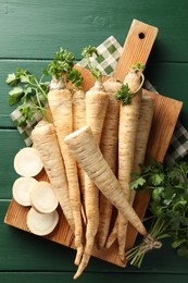 Photo of Parsley roots and leaves on green wooden table, top view