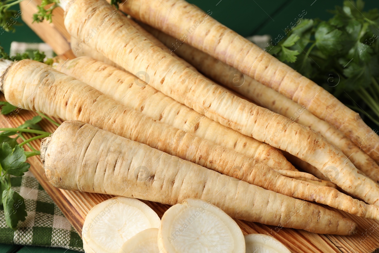 Photo of Parsley roots and leaves on green wooden table, closeup