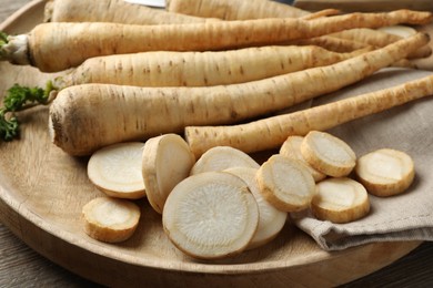 Photo of Raw parsley roots on wooden table, closeup