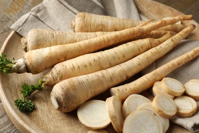 Photo of Raw parsley roots on wooden table, closeup