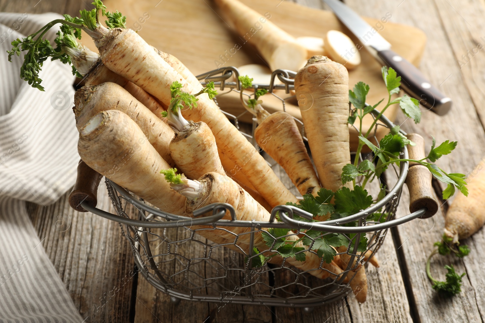 Photo of Raw parsley roots with leaves on wooden table