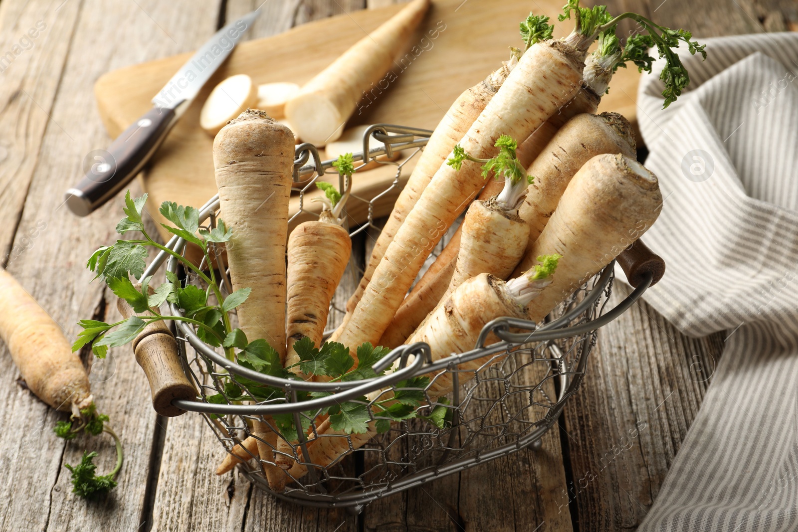 Photo of Raw parsley roots with leaves on wooden table