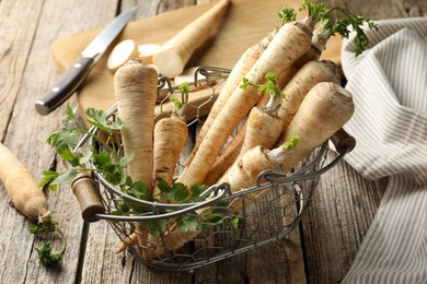 Photo of Raw parsley roots with leaves on wooden table