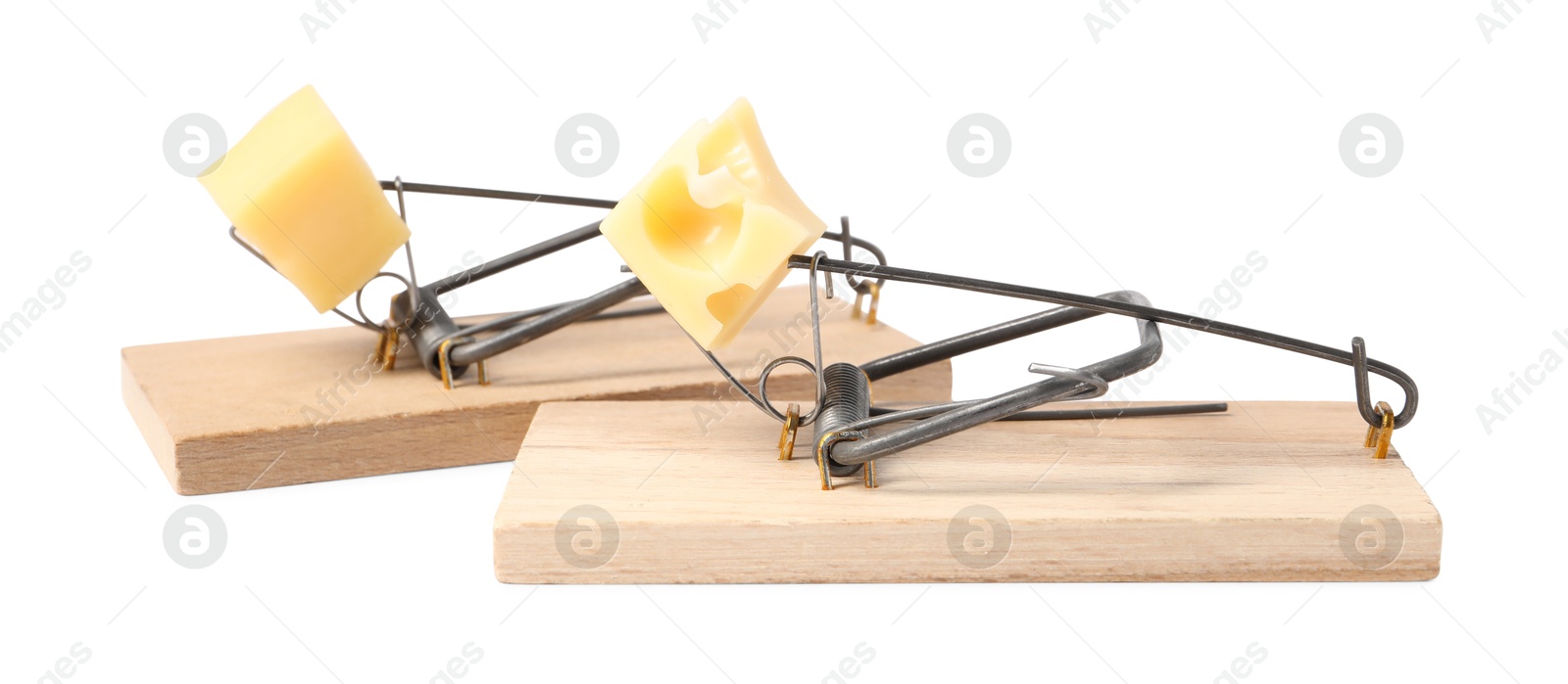 Photo of Two spring-loaded bar mousetraps with pieces of cheese isolated on white