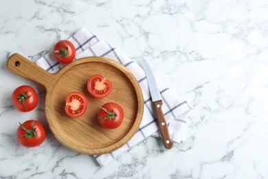 Photo of Wooden cutting board, tomatoes and knife on white marble table, flat lay. Space for text