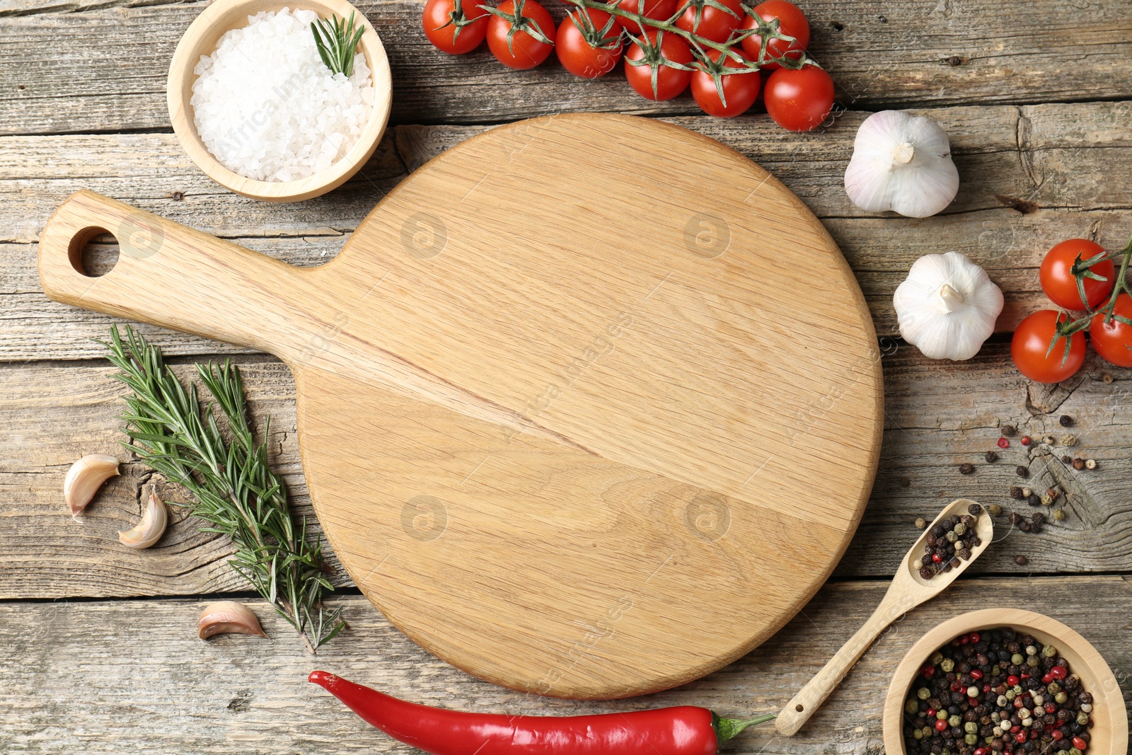 Photo of Cutting board and different products on wooden table, flat lay. Space for text