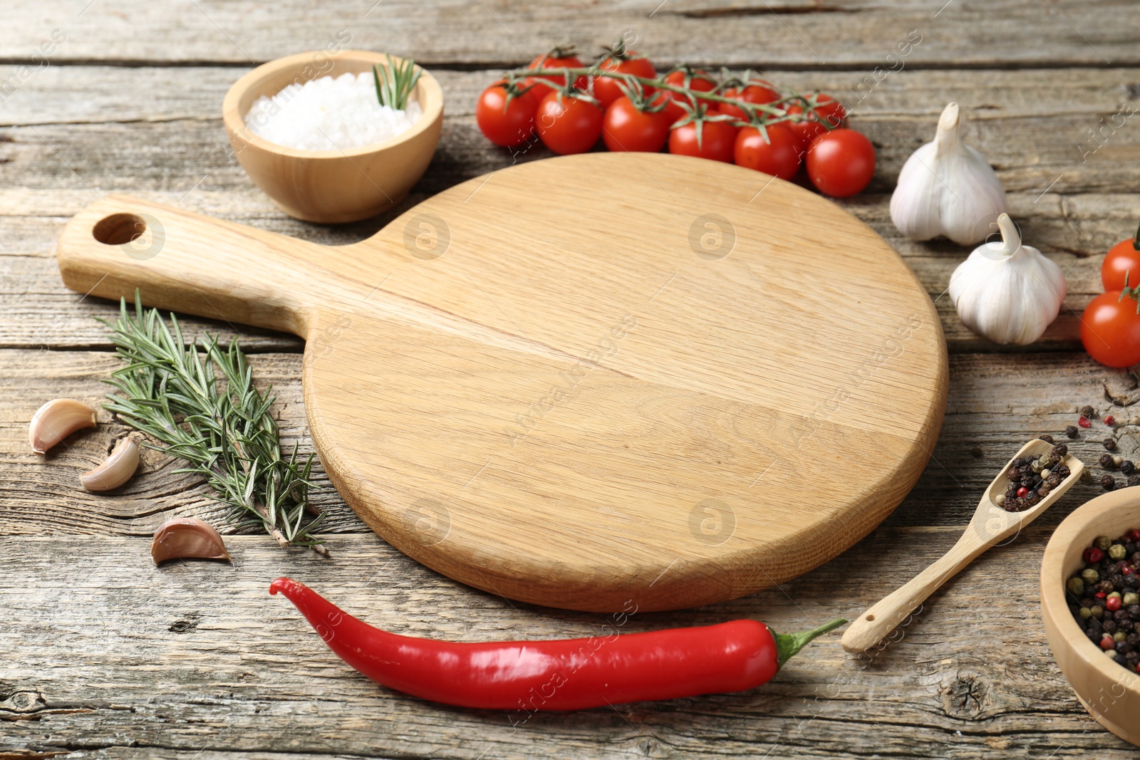 Photo of Cutting board and different products on wooden table