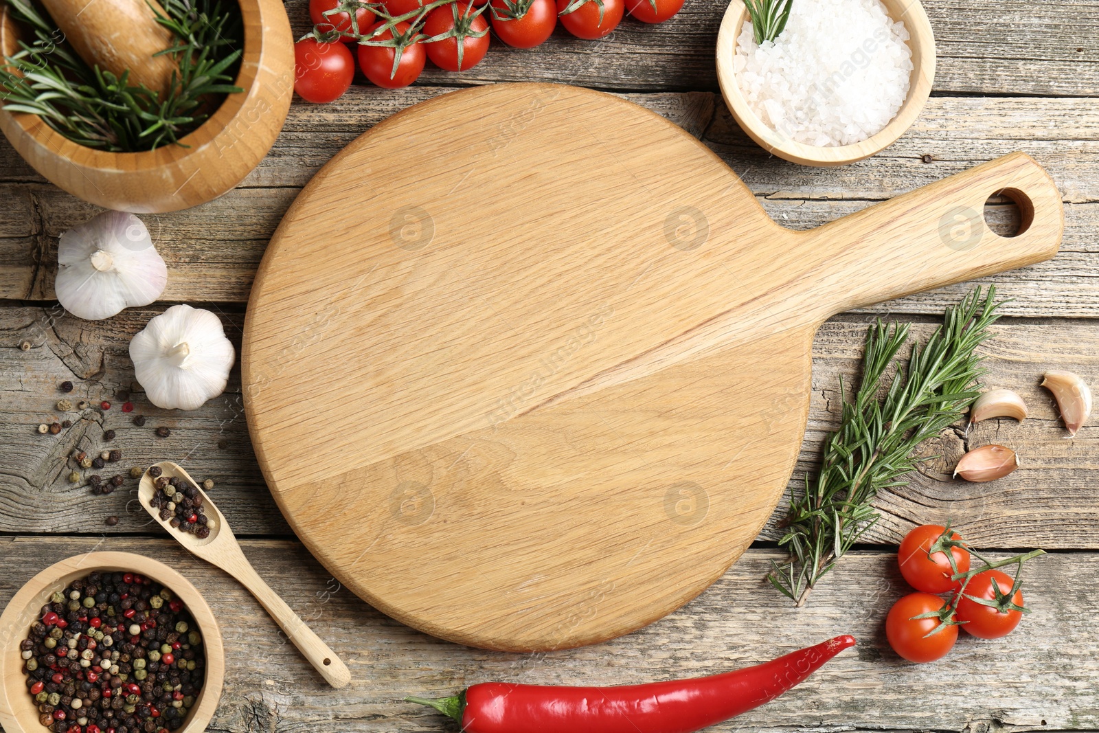 Photo of Cutting board and different products on wooden table, flat lay. Space for text