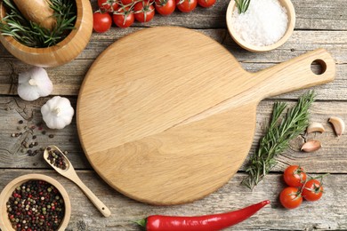 Photo of Cutting board and different products on wooden table, flat lay. Space for text