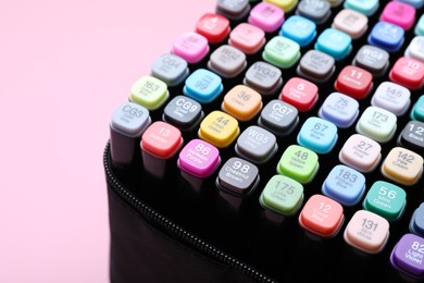 Photo of Many colorful markers in bag on pink background, closeup