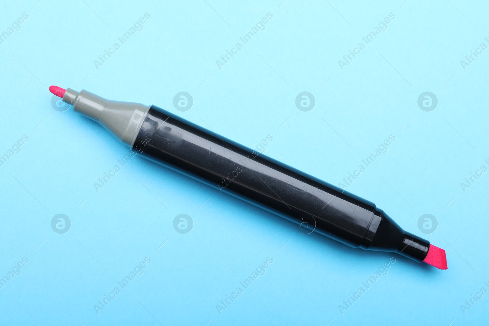 Photo of One double sided marker on light blue background, top view