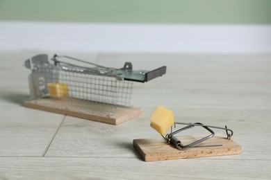 Photo of Two different mouse traps with bait indoors, closeup