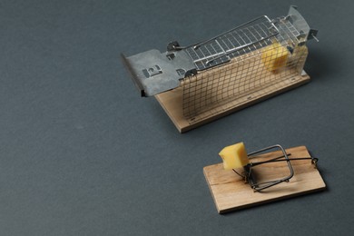 Photo of Two different mouse traps with bait on gray background, space for text