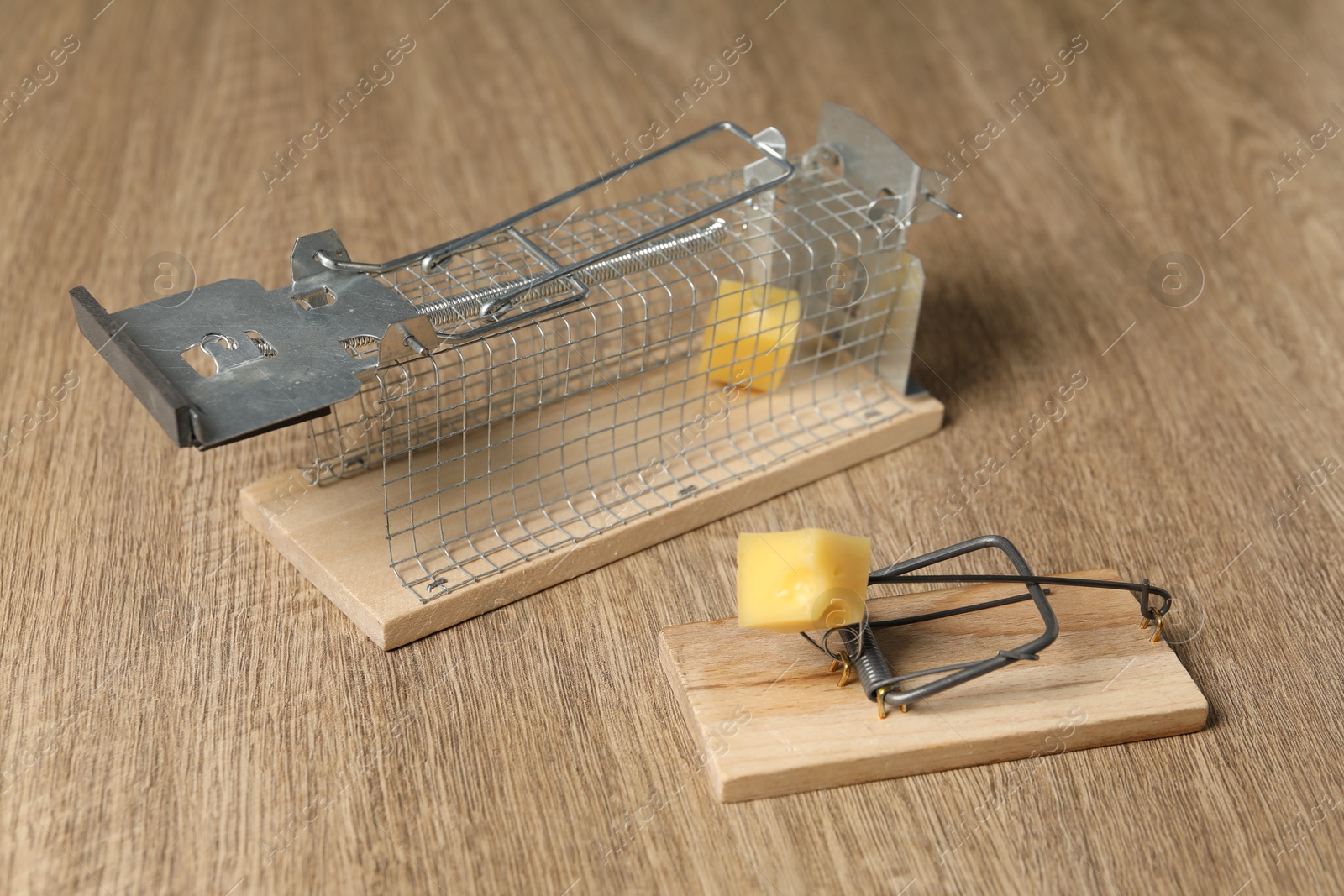 Photo of Two different mouse traps with bait on floor, closeup