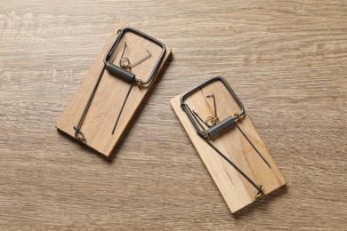 Photo of Two spring-loaded bar mousetraps on floor, flat lay