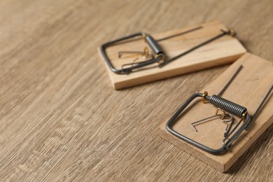 Photo of Two spring-loaded bar mousetraps on floor, closeup. Space for text