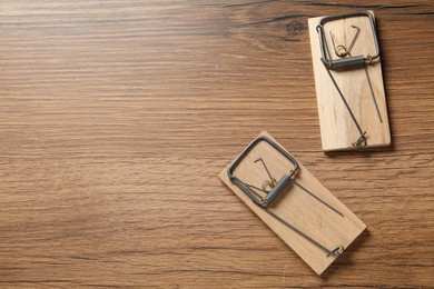 Photo of Two spring-loaded bar mousetraps on floor, flat lay. Space for text