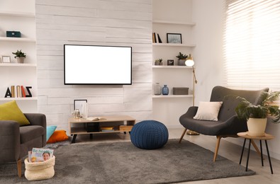 Image of Tv set with white screen mounted on wall in room. Mockup for design