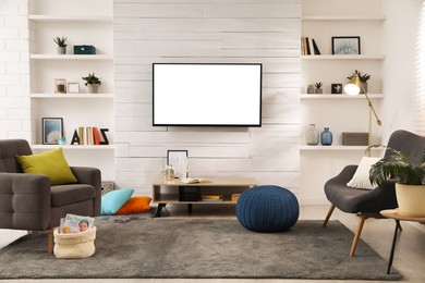 Image of Tv set with white screen mounted on wall in room. Mockup for design