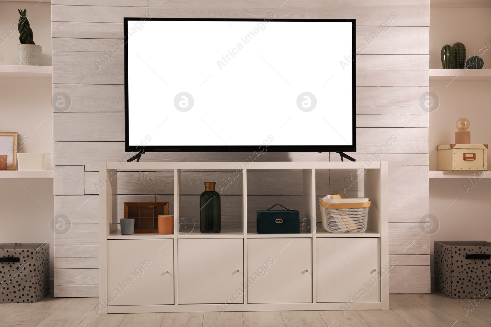 Image of Tv set with white screen on stand in room. Mockup for design