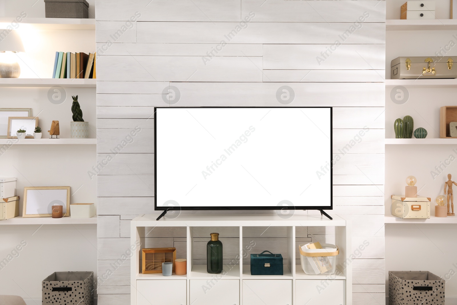 Image of Tv set with white screen on stand in room. Mockup for design