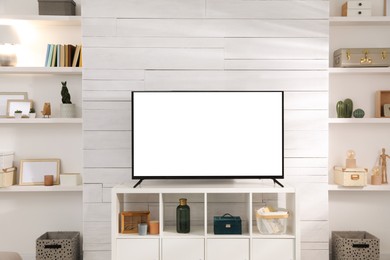 Image of Tv set with white screen on stand in room. Mockup for design