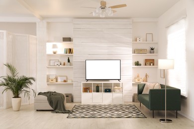 Image of Tv set with white screen on stand in room. Mockup for design