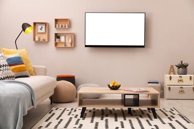 Image of Tv set with white screen mounted on wall in room. Mockup for design