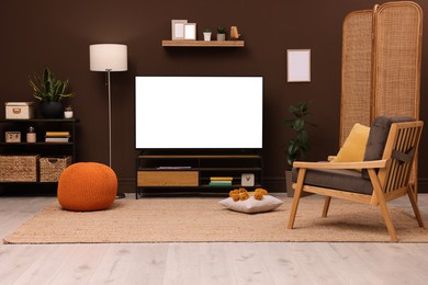 Image of Tv set with white screen on stand in room. Mockup for design